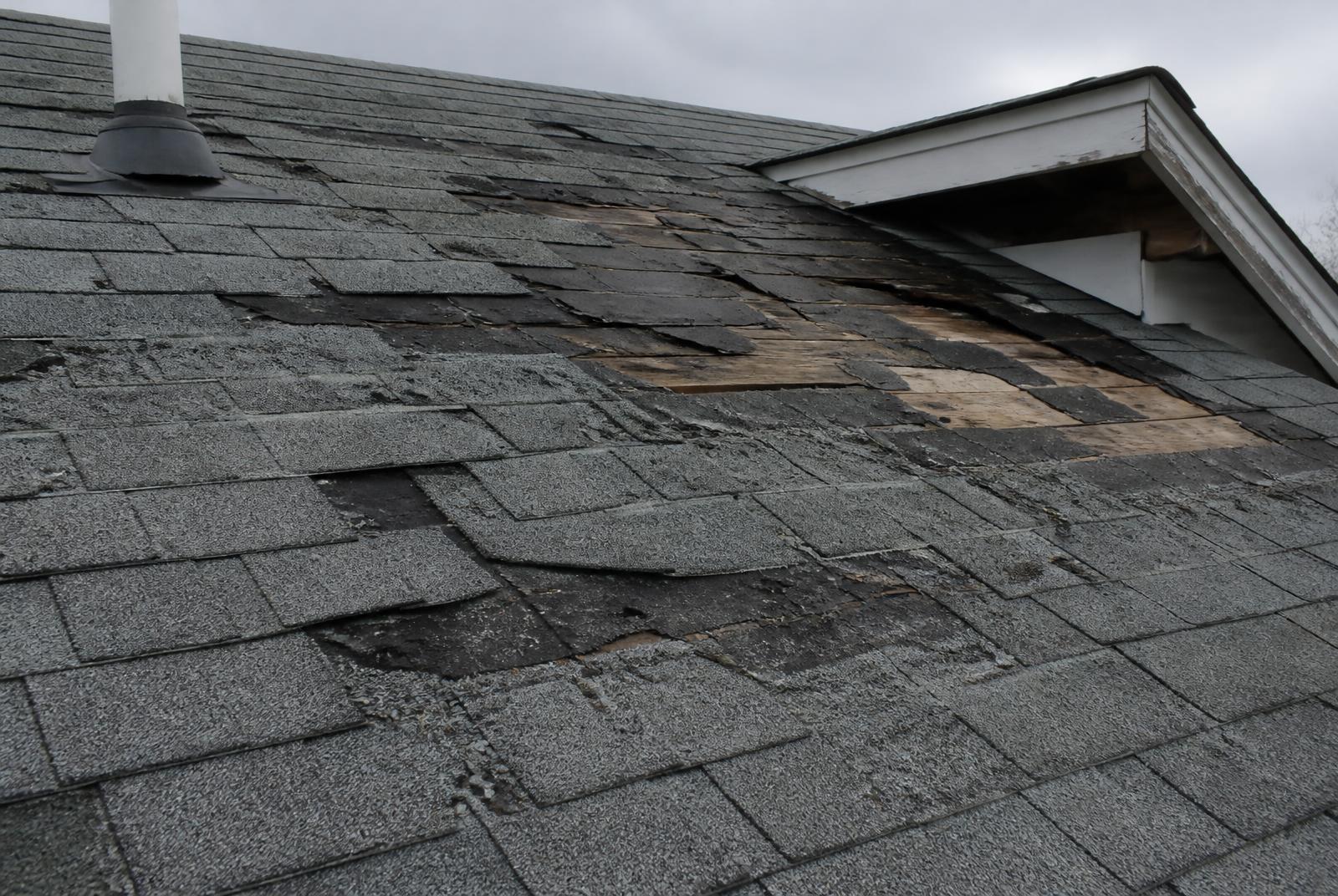 Storm-damaged asphalt shingle roof with missing shingles documented for a roofing Xactimate estimate